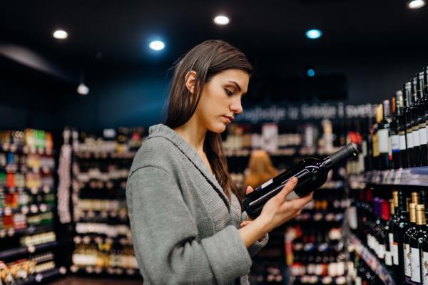 woman chooses bottle of wine